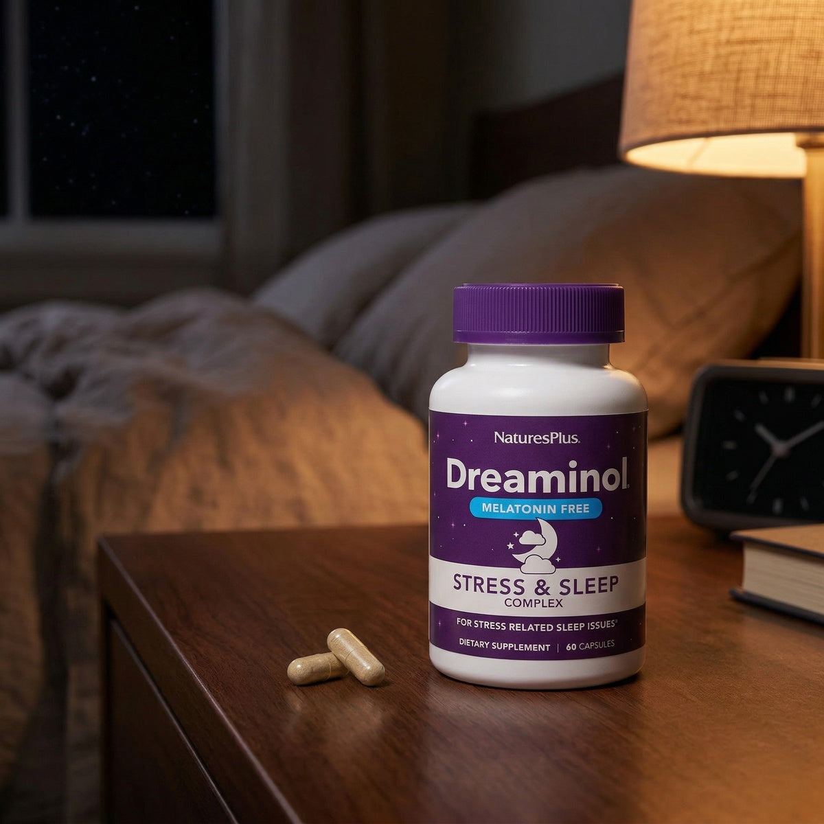 NTP354 | NaturesPlus Dreaminol stress and sleep supplement bottle with capsules on a bedside table