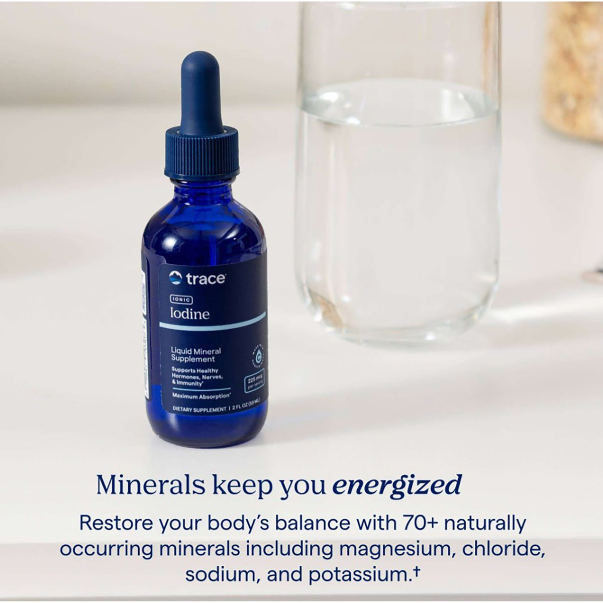 TM083 | Trace Ionic Iodine liquid mineral supplement bottle beside a glass of water with promotional text