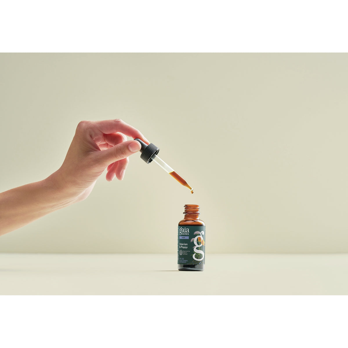 GH179 | Hand using dropper above Gaia Herbs Valerian & Poppy bottle