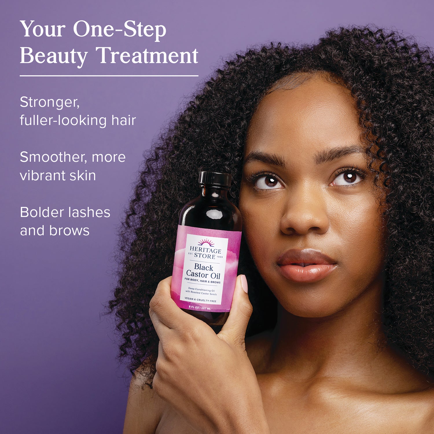 HTG104 | Woman holding Heritage Store Black Castor Oil bottle with overlay text touting stronger fuller hair and bolder lashes and brows