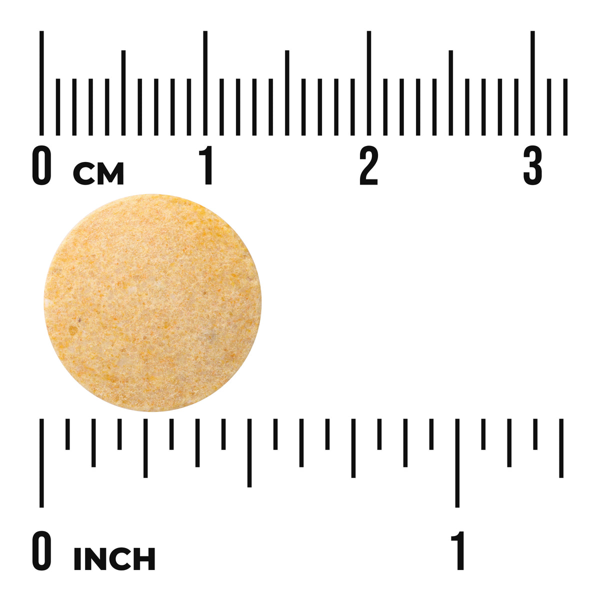 Round tablet with size reference against cm and inch rulers