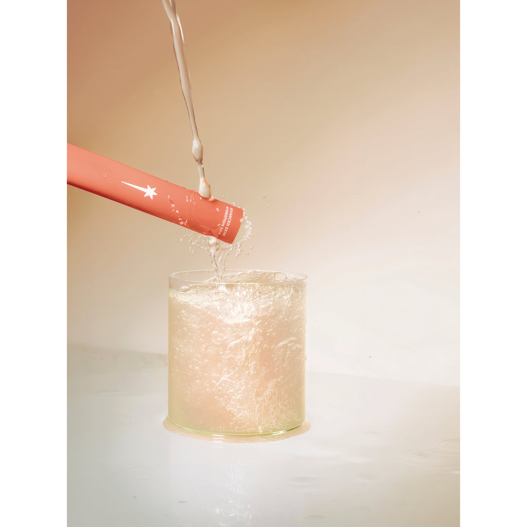 KTO001 | Red cosmetic wand stirring a foaming liquid in a clear glass - Thumbnail