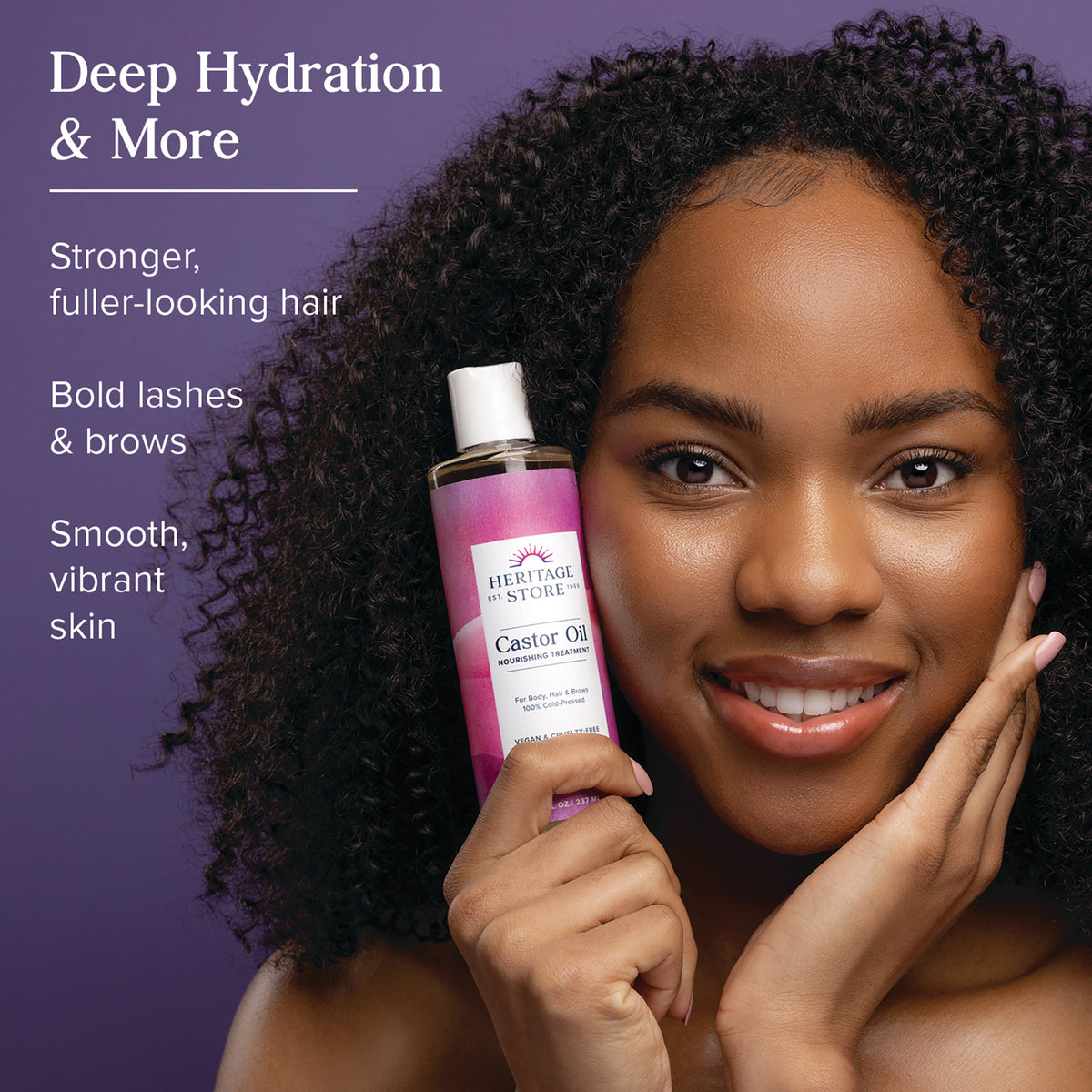 HTG023 | Smiling woman holding Heritage Store Castor Oil bottle against purple background with text Deep Hydration & More