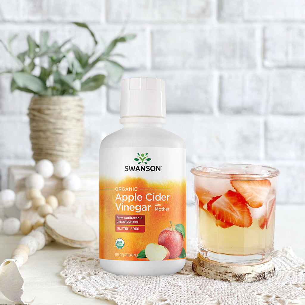 SWF195 | Swanson Organic Apple Cider Vinegar with Mother bottle beside iced drink with sliced strawberries - Thumbnail